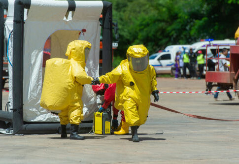 Hazmat-suited workers exit a decontamination tent