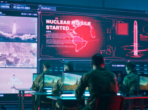 Military personnel monitor a command center screen showing missile launch alerts