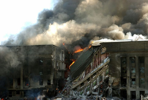 burning building with heavy smoke and collapsed sections