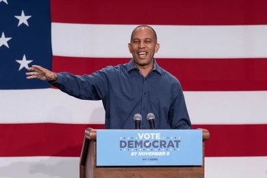 Speaker at podium in front of large American flag